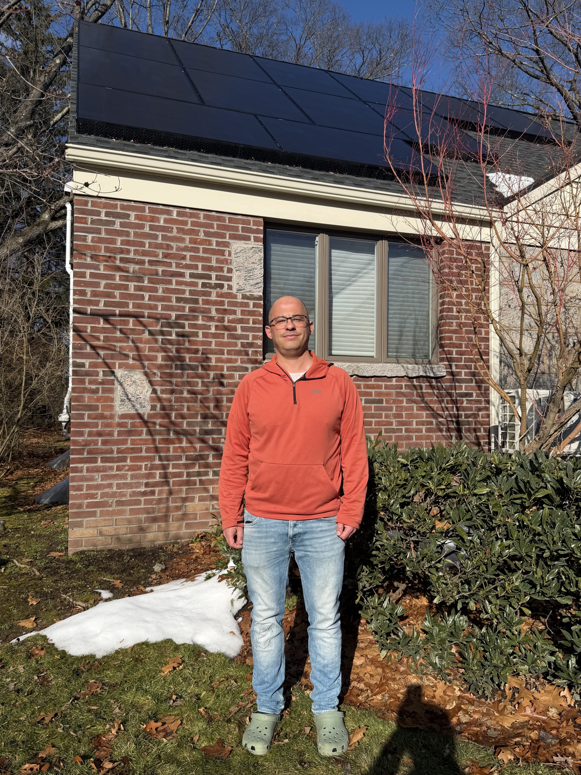 proud homeowner in front of solar panels in new jersey