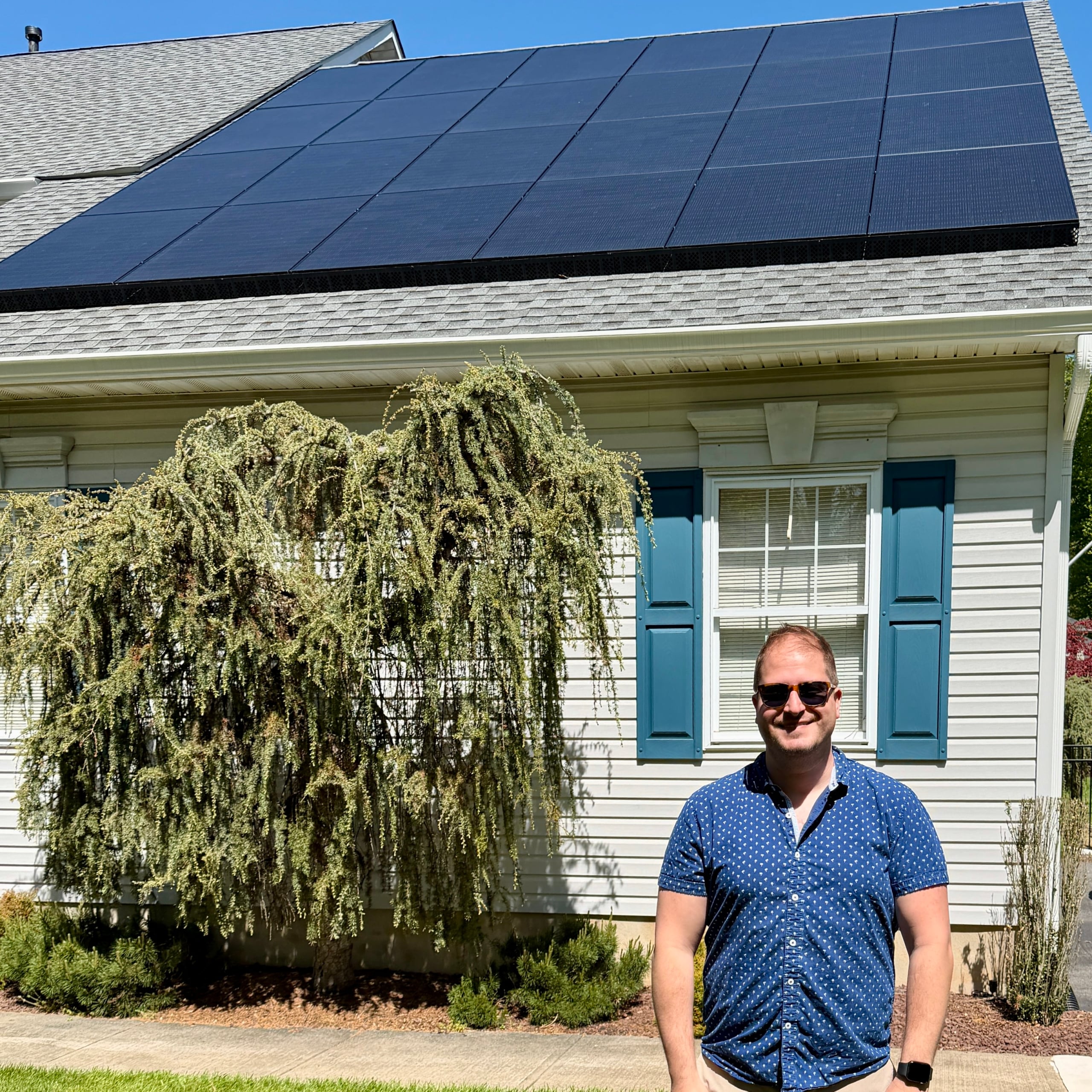 homeowner in front solar panels in Robbinsville NJ